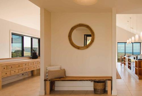 a mirror on a wall above a bench in a room at Excelsa- sweeping valley in Rose Valley