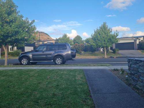 a black suv parked on the side of a street at Affordable Luxury One Bedroom Apartment in Pukekohe in Pukekohe East