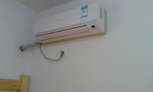 un condizionatore d'aria su una parete in una stanza di Makerhouse Hostel a Hefei