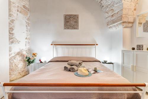 een slaapkamer met een bed met een hoed en een bord bij Maison de Antonelle in Ostuni