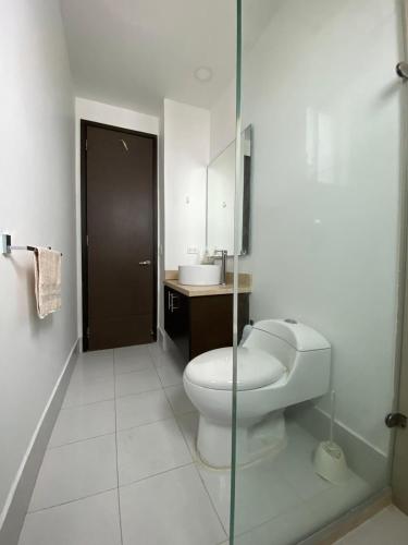 a white bathroom with a toilet and a sink at Oceanfront Luxury - A pasos del Centro Histórico in Cartagena de Indias
