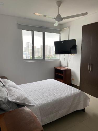 a bedroom with a bed and a flat screen tv at Oceanfront Luxury - A pasos del Centro Histórico in Cartagena de Indias