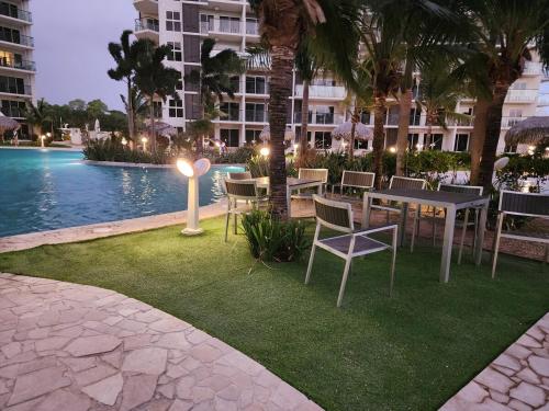 Un patio con mesa y sillas junto a una piscina. en Oceanfront, Caracol Beach, en El Quindio