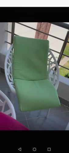 a green pillow sitting in a chair on a porch at قرية مارسيليا بيتش فور in Sīdī ‘Abd ar Raḩmān