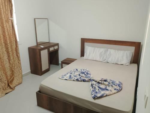 a bedroom with a bed and a dresser and a mirror at قرية مارسيليا بيتش فور in Sīdī ‘Abd ar Raḩmān