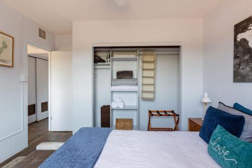 a bedroom with a white bed with blue pillows at Spring Escape 1BR by UA DT Just 2 Min to Banner in Tucson