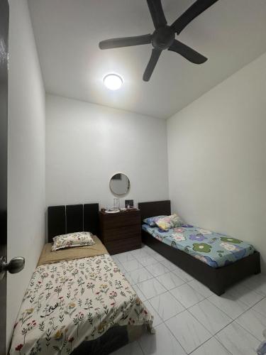 a bedroom with two beds and a ceiling fan at Tuaran 88 Homestay in Tuaran
