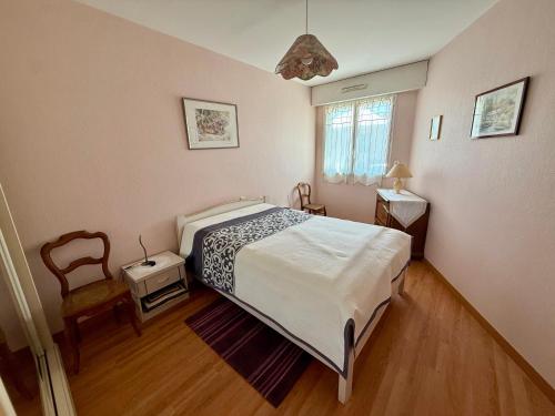 une chambre avec un lit et une chaise dans l'établissement Appartement T3 avec terrasse et garage à 300 m de la plage, quartier Arago - FR-1-92-582, à Les Sables-dʼOlonne