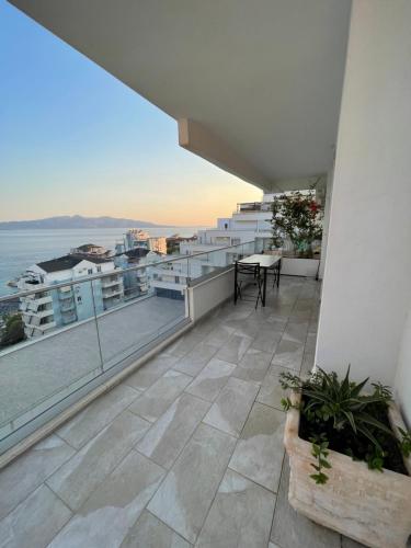 a balcony with a table and a view of the ocean at Marin Apartments Saranda Terrace in Sarandë