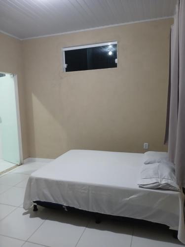 a bedroom with a bed and a tv on the wall at Casa Jacuipe temporada in Camaçari