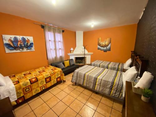 a bedroom with two beds and a fireplace at Hotel y Restaurante San Fernando. in Jocotenango