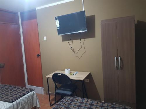 a room with a desk with a chair and a tv at Habitación con doble cama privada en Talara centro in Talara