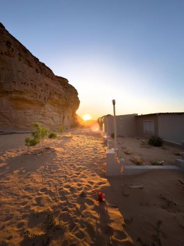 a sunset on a beach near a cliff at استراحه كيان in AlUla
