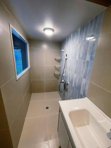 a bathroom with a shower and a sink at アロハ鎌倉 in Kamakura