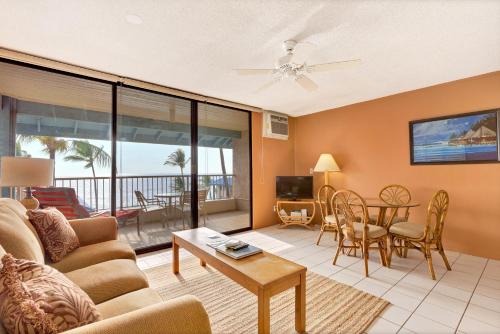 a living room with a couch and a table at Castle At Kona Reef in Kailua-Kona