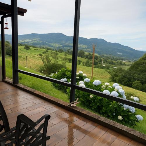 a view from the porch of a house with flowers at La Cabaña in Heredia