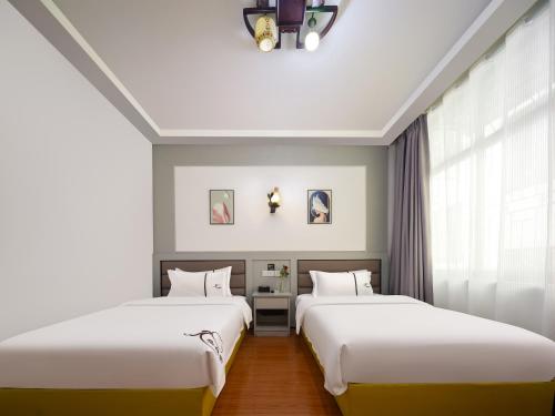 Postel nebo postele na pokoji v ubytování Zhangjiajie Fuluju Inn