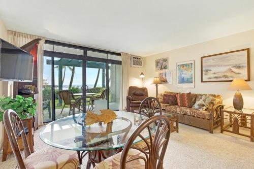 a living room with a glass table and a couch at Castle At Kona Reef in Kailua-Kona