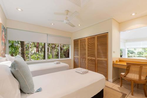 a bedroom with two beds and a desk and a window at Mirage Resort Villa 438 with access to Sheraton Facilities in Port Douglas