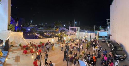 a crowd of people standing outside a building at night at Hotel Leblanc Suites in Puerto La Cruz