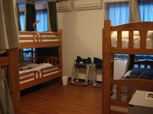 a dorm room with three bunk beds and a desk at YAKUSHIMA REFRESH ROOM in Yakushima