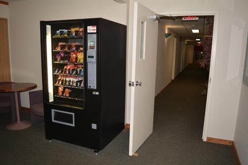 a black refrigerator in a hallway next to a corridor at Chalet Continental Motel in Valemount