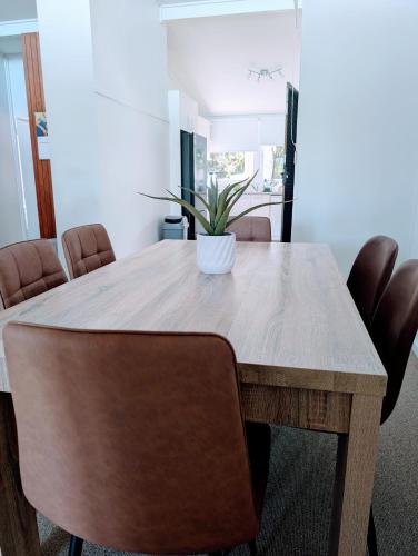 a dining room table with a potted plant on it at Leafy 3-Bedroom Escape to Nature-Air Conditioned with Smart Entry in Ferny Hills