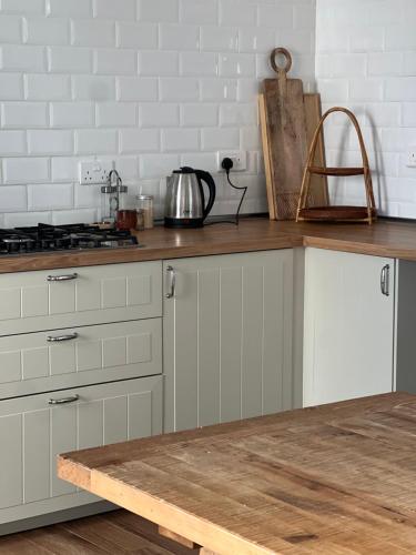 eine Küche mit weißen Schränken und einer Arbeitsplatte in der Unterkunft Orchid Boutique Chalet in Barka