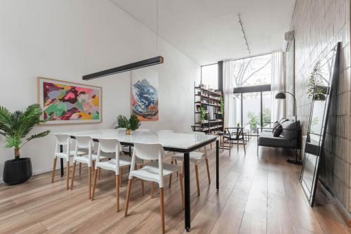 une salle à manger avec une table et des chaises blanches dans l'établissement Fliphaus Villa Honduras 5700 - Lux 5 Bd Gastronomic Area Daily Housekeeping!, à Buenos Aires