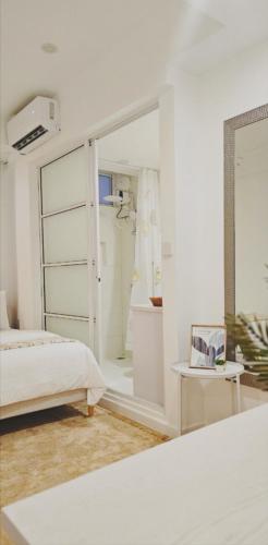 a white room with a bed and a mirror at Nala Host - 2BR Apartment Seaside Bliss in Hulhumale