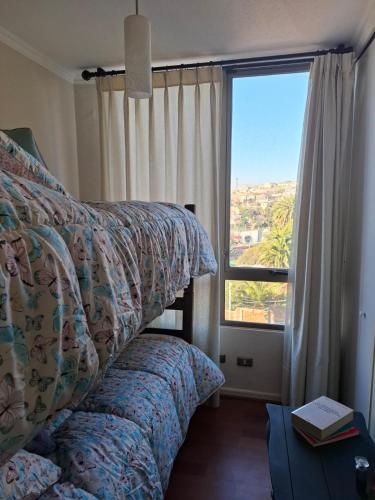 a bedroom with two beds and a large window at Departamento de Lina in Valparaíso