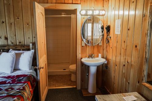 a bathroom with a sink and a bed and a mirror at Heart Six Ranch in Moran