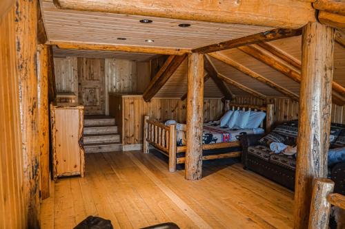 a bedroom with two beds in a log cabin at Heart Six Ranch in Moran