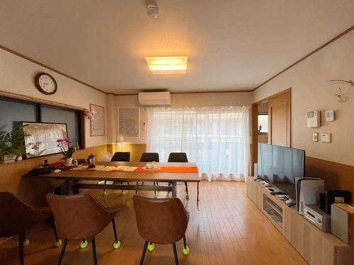 a room with a table and chairs and a television at 大阪一番駅 in Osaka