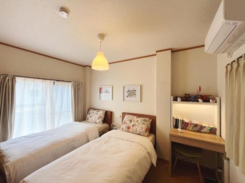 two beds in a room with a window at 大阪一番駅 in Osaka