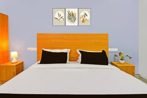 a bedroom with a large bed with a wooden headboard at Hotel O RBS Square Inn Uppal in Hyderabad