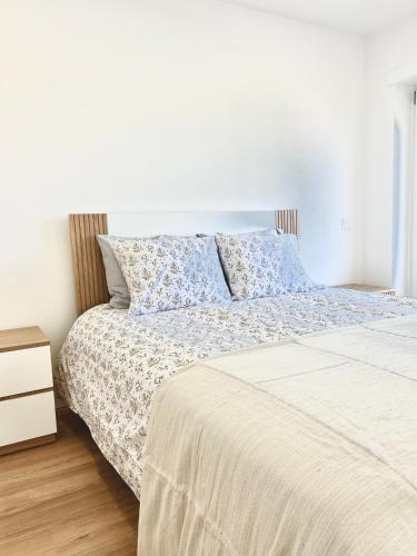 a bedroom with a bed and a night stand at Figueira Luxury Comfort House in Figueira da Foz