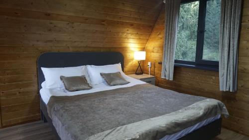 a bedroom with a large bed with two pillows at Zhyluu Suu Resort BozUchuk in Novovoznesenovka