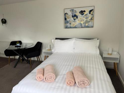 a bedroom with a white bed with pink towels on it at One bedroom studio in Moffat