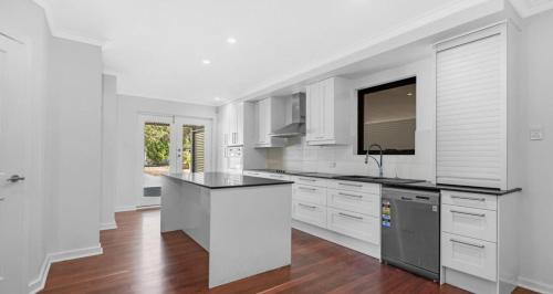 a kitchen with white cabinets and a black counter top at Nestled in Swan Valley area in West Swan