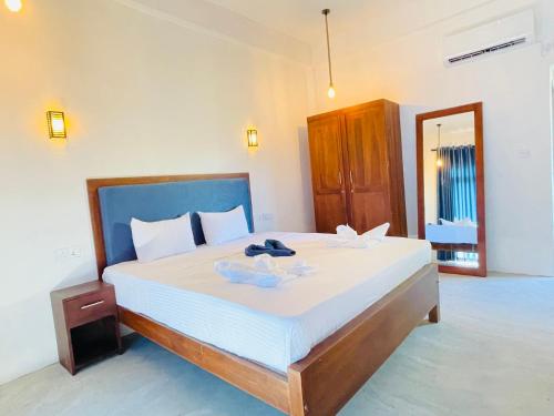 a bedroom with a large bed with white sheets at Doppel Gangs Arugambay in Arugam Bay
