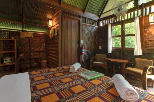 a bedroom with a bed and a table and chairs at Our Jungle House in Khao Sok