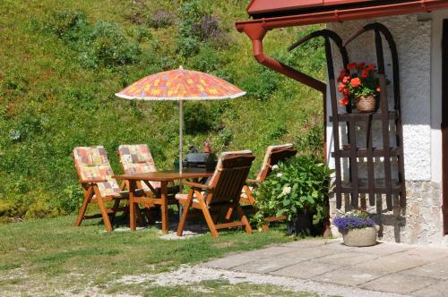 a table and chairs with an umbrella in a yard at Penzion Hainiš in Janske Lazne