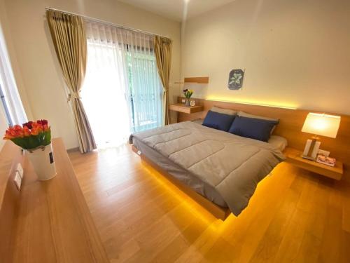 a bedroom with a large bed with a wooden floor at ทรีส์เฮาส์ Tree's House in Udon Thani