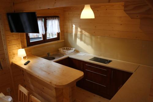 eine Küche mit einem Waschbecken und einer Theke in einer Hütte in der Unterkunft Domek z Bala Pod Żaglami in Pobierowo