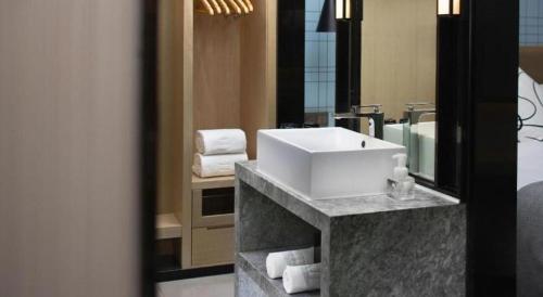 a bathroom with a sink and towels on a counter at Echarm Hotel Jingjiang Bus Passenger Station Fanggu Street in Jingjiang