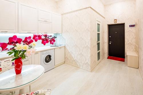 a kitchen with a table and a vase of flowers at Crystal Apartments in Lviv