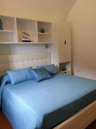 a bedroom with a large bed with blue pillows at Casa Vacanze Bouganvillea in Cetara