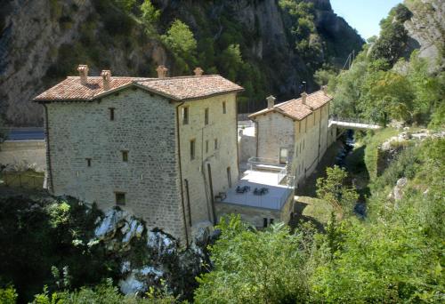 eine Gruppe von Gebäuden an der Seite eines Berges in der Unterkunft Appartamenti Molino Settecamini in Gubbio