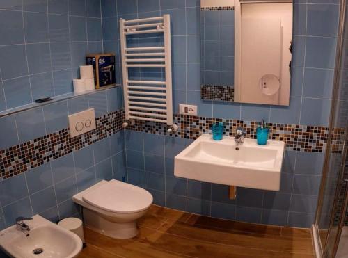 bagno piastrellato blu con servizi igienici e lavandino di Rosa Dei Venti a Riomaggiore